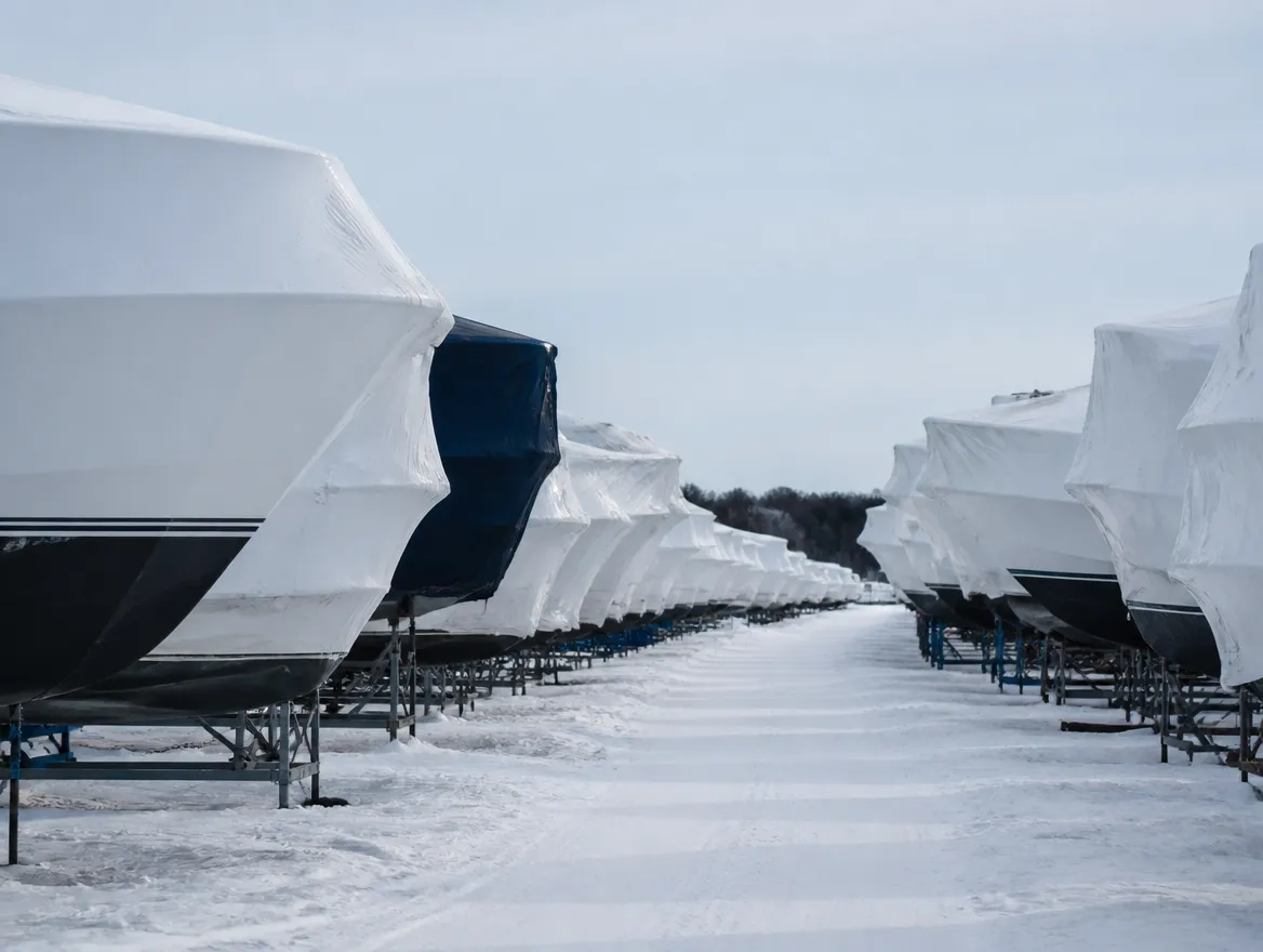 Rows of shrink-wrapped boats under fresh snow